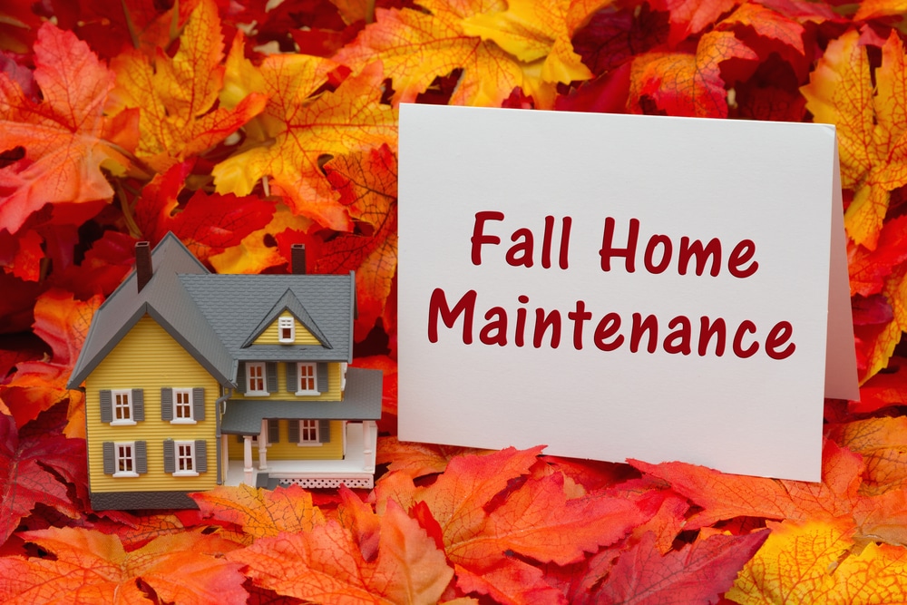 Inspect roof for fall maintenance, surrounded by colorful autumn leaves.